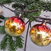 runde-gamle-glas-julekugler-rod-top-gron-bund-hvide-stjerne-på-guldmidterstykke-gammel-juletraespynt